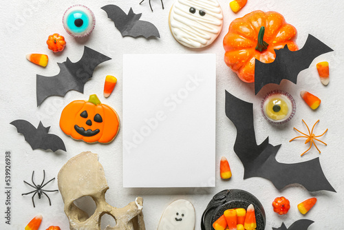 Composition with blank card and Halloween decor on light background