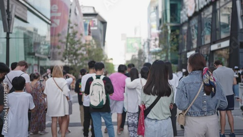 Wallpaper Mural Back view of a young asian teenager standing at an outdoor concert on the street of the city center Torontodigital.ca