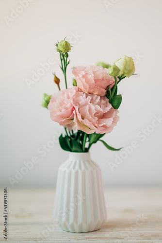Beautiful pink bouquet of flowers in the vase on the table. Cozy home decoration and festive decor