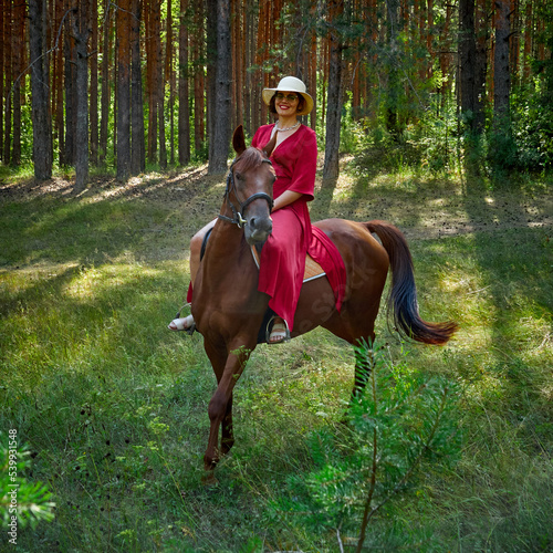 Woman in red dress rides a horse in early spring © Max
