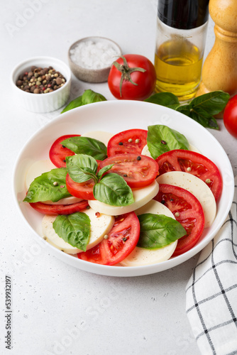 Caprese salad made of sliced fresh tomatoes, mozzarella cheese and basil.