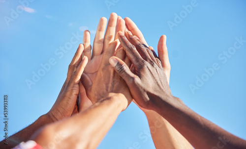 Fototapeta Naklejka Na Ścianę i Meble -  High five, sports and team with support, motivation and solidarity during a game with a blue sky. Group of people, athlete friends or men with hands together for a win, success and partnership