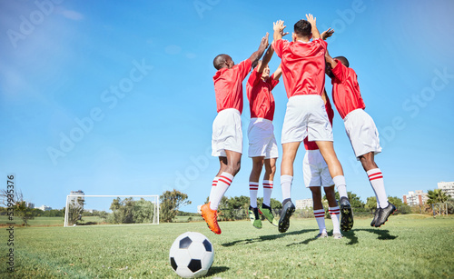Fototapeta Naklejka Na Ścianę i Meble -  Soccer, sports and motivation with a team jumping on a grass pitch or field during training or practice. Fitness, football and exercise with an athlete group celebrating together during a workout