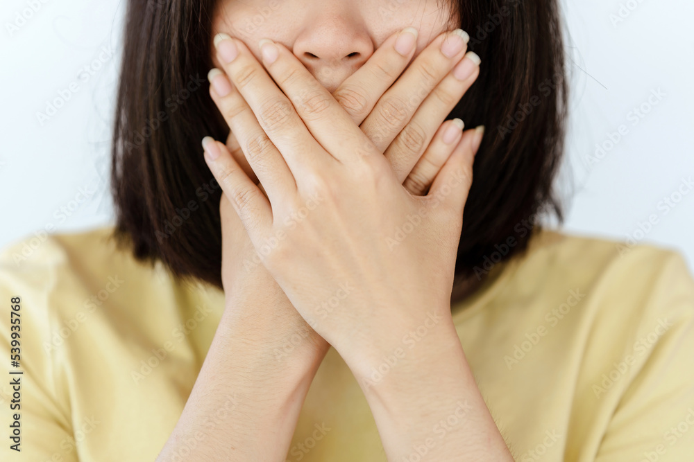 The woman covered her mouth with her hand. The woman covered her mouth with her hand.