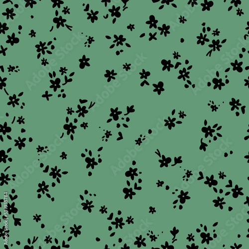 seamless vintage pattern. small black flowers and leaves. green  background. vector texture. fashionable print for textiles and wallpaper.