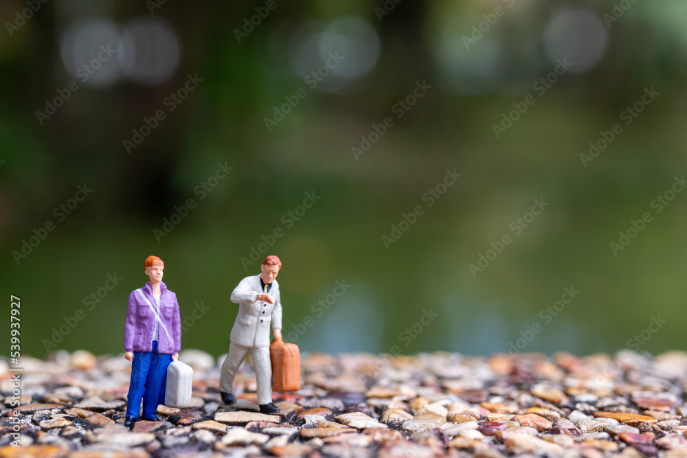 Fototapeta premium Miniature people Couple strolling down the street has a background of greenery