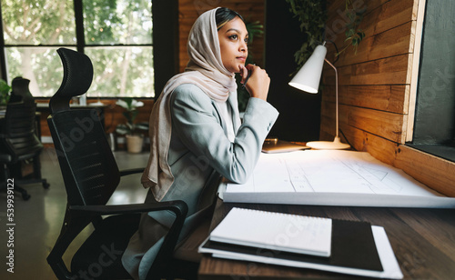 Thoughtful Muslim achitect working in a coworking space photo