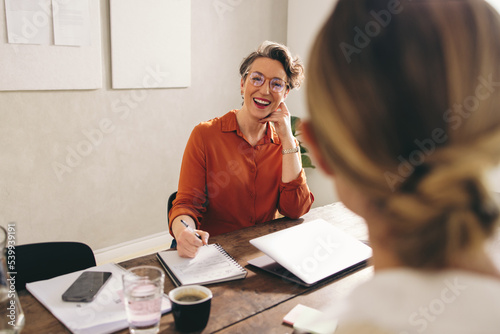 Happy businesswoman interviewing a job candidate in her office