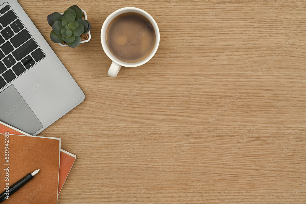 Flat lay, cup of coffee, laptop computer, notebook and succulent plant on wooden office desk. Top view with copy space Flat lay, cup of coffee, laptop computer, notebook and succulent plant on wooden office desk. Top view with copy space