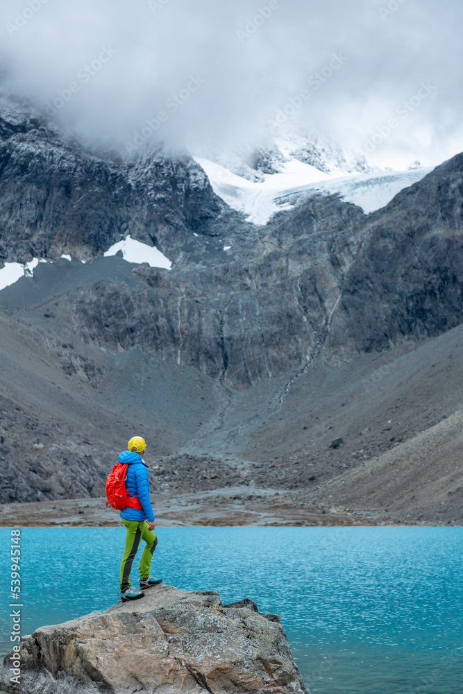 Woman enjoys  Blaisvatnet, Blue lake is a polular hiking destination, with mountains of the Lyngen Alps, Lyngenfjord, Troms og Finnmark, Norway