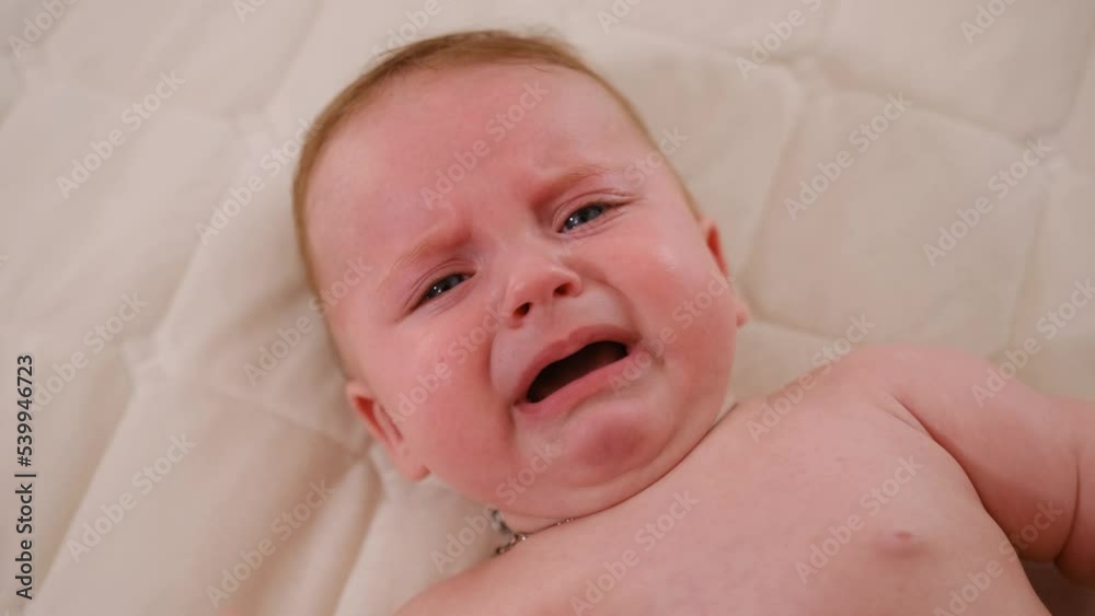 Close-up face of infant crying. Caucasian baby yelling. Child crying. Slow motion video of a little newborn in a bad mood Close-up face of infant crying. Caucasian baby yelling. Child crying. Slow motion video of a little newborn in a bad mood