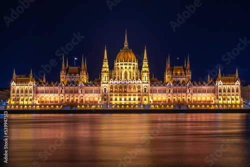Budapeszt budynek parlamentu Országház oświetlony nocą nad rzeką Dunaj.