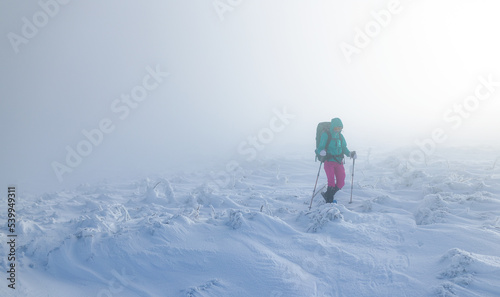 A woman in the winter trekking during the fog