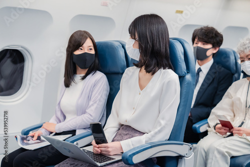マスクをして飛行機に乗る乗客