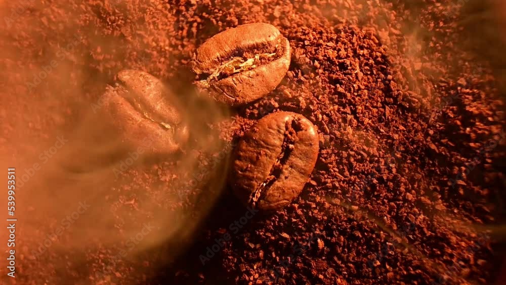 Video with roasted coffee beans close-up and light smoke, coffee illumination with warm light.