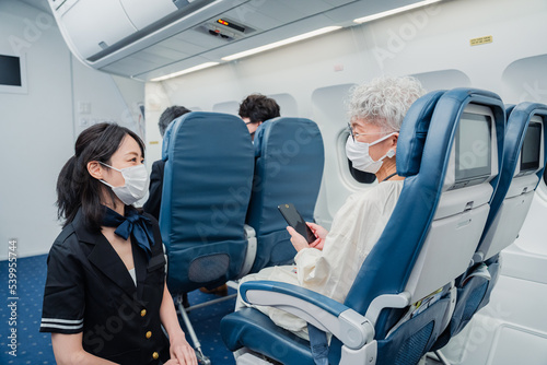 マスクをして機内サービスをする客室乗務員