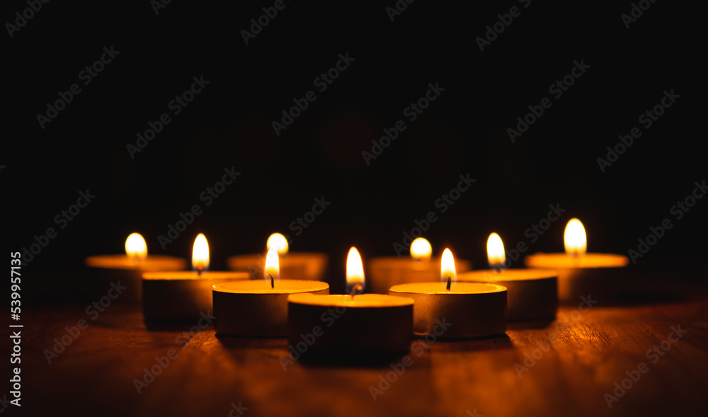 Burning Golden light of candle on black background, Mourning, grief, christmas candle light concept.