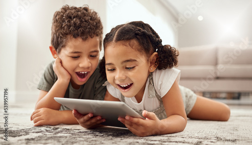 Tablet, children and family with a brother and sister watching movies on a living room floor together. Internet, kids and technology with a girl and boy streaming online subscription service at home
