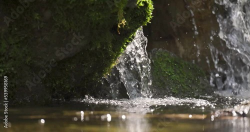 Slow motion of small waterfall stream at a water pond in the forest