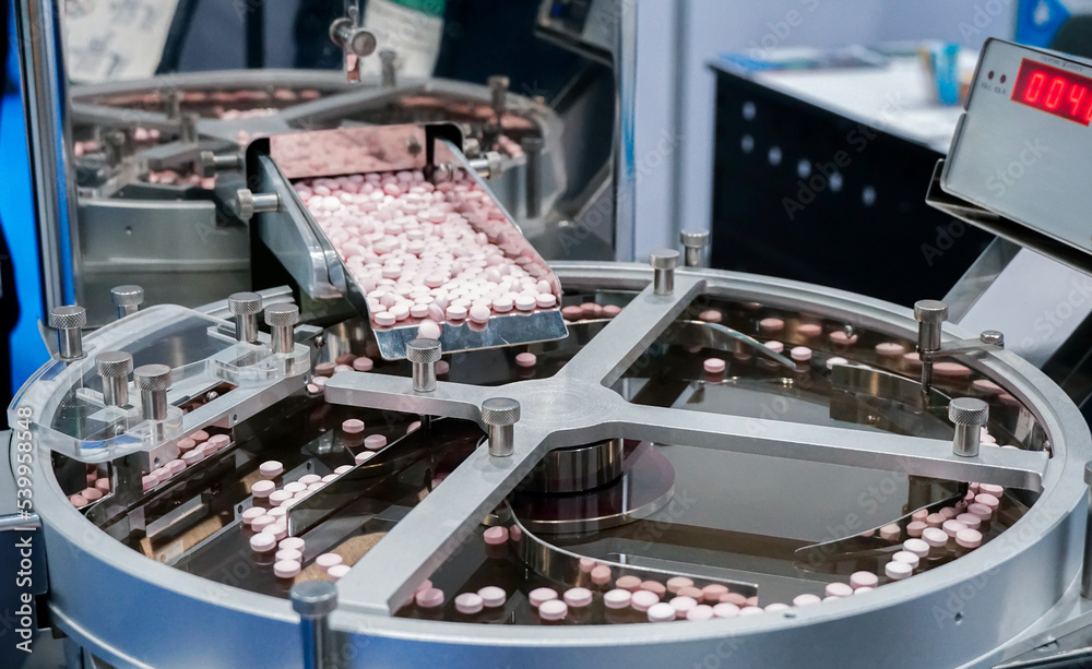 Closeup of pharmaceutical medicine tablet pill production, pharmacy medicine capsule pill in production line at medical factory. 