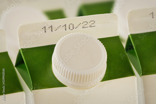 Close-up of milk cartons with expiration date