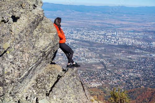 Woman sitting on a rocks high in the autumn mountain above the city of Sofia. Vitosha mountain, ,Bulgaria