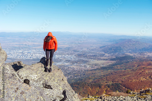 Woman sitting on a rocks high  in the autumn  mountain above the city of Sofia. Vitosha mountain,  ,Bulgaria photo