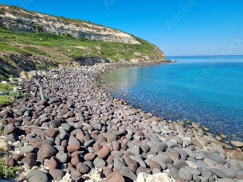 black lava stone beach at sinis peninsula, sardinia, italy photo