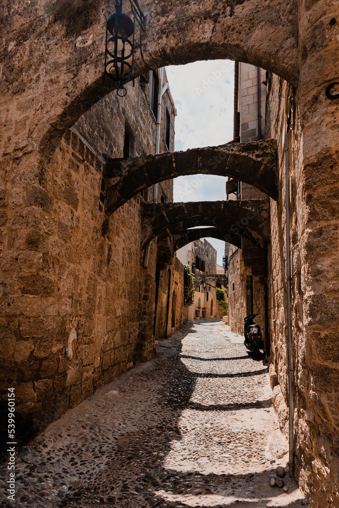 Fototapeta premium Narrow cobbled historical streets in Old Town of Rhodes, Dodecanese, Greece. High quality photo