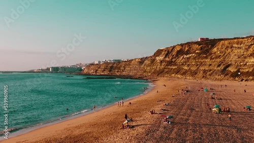 People Doing Activities On Wide Foz De Lizandro Beach Under High Rocky Ciffs, Portugal photo