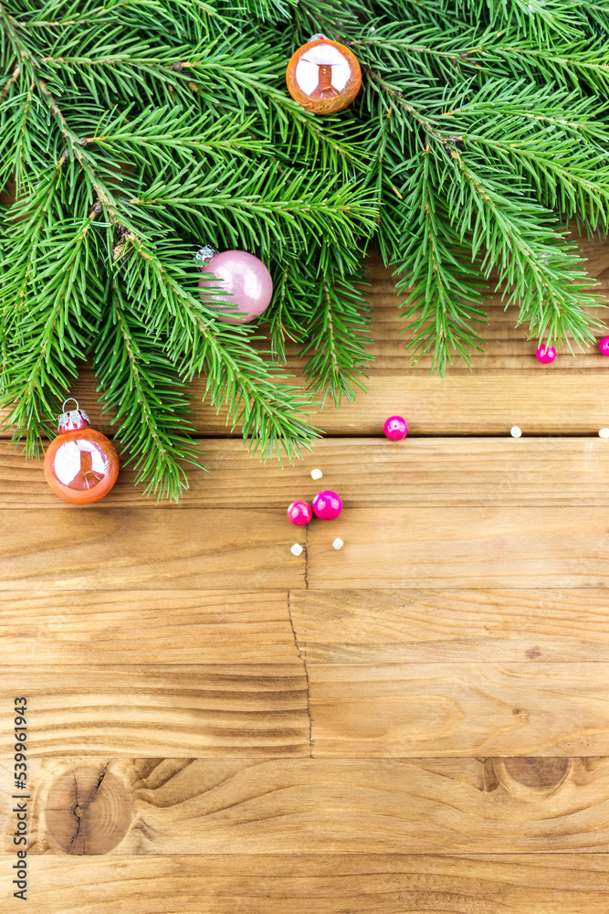 Top view of Christmas (New Year) decoration composition. Fur-tree branches, pink and golden glass balls on wooden background Top view of Christmas (New Year) decoration composition. Fur-tree branches, pink and golden glass balls on wooden background