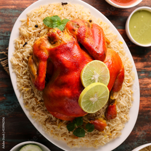 Arabic chicken Manthi or mandi cooked meat, Basmati rice with Masala, spice. Kuzhimanthi or hot and spicy Manthi on black background in Malabar Kerala, South India. Top view of Indian non veg food. photo