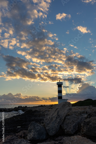 Sonnenuntergang mit letzten Sonnenstrahlen über dem Leuchtturm Sa Punta Plana Mallorca Balearen