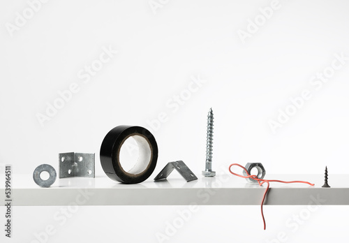 Composition with fastening tools and adhesive tape on white background. Tools for repair and improvement. Industrial decoration in showcase (ID: 539964511)