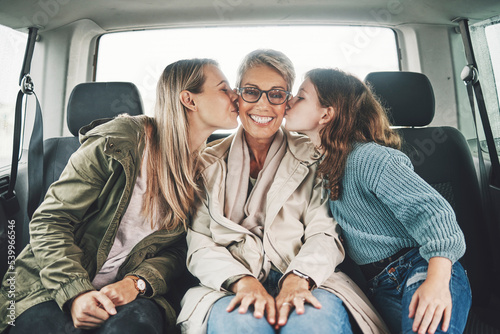 Family, kiss and road trip with a girl, mother and grandmother in the backseat of a car for a drive. Love, travel and transport with a senior woman, daughter and granddaughter on vacation or holiday © Allistair F/peopleimages.com
