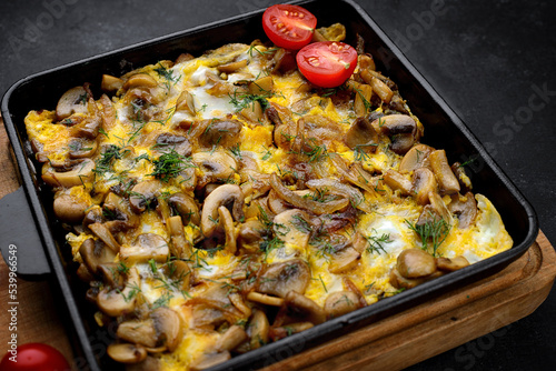 Omelet with mushrooms, onions and dill, in a frying pan