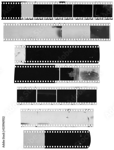 Old, used, dusty and scratched celluloid film strips on transparent background