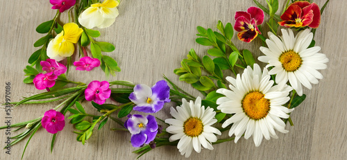 Floral pattern of chamomiles  phloxes and violas on a wooden background. Wide photo for postcards.