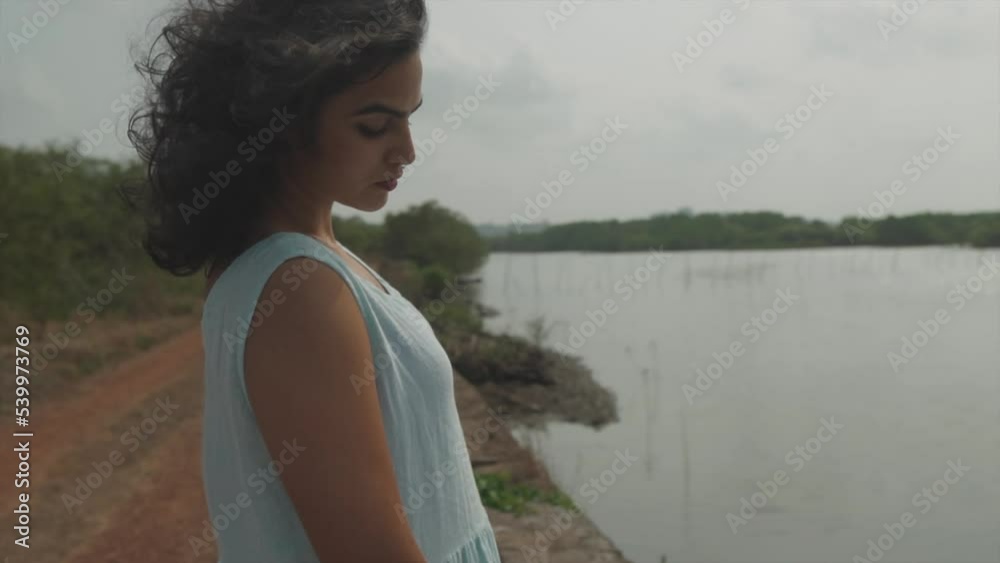 Close-up of a woman near the river with her hair blowing in the wind Close-up of a woman near the river with her hair blowing in the wind