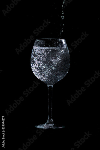 water pouring into glass on black background