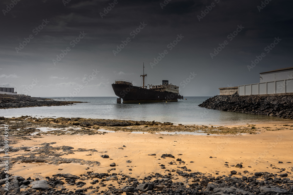 The Telamon shipwreck on the sea under a cloudy sky in Lanzarote Island , Spain