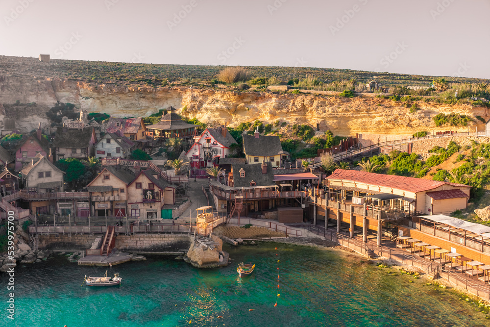 Mellieha, Malta, 21 May 2022:  Sunset over the Popeye Village and its crystal clear water