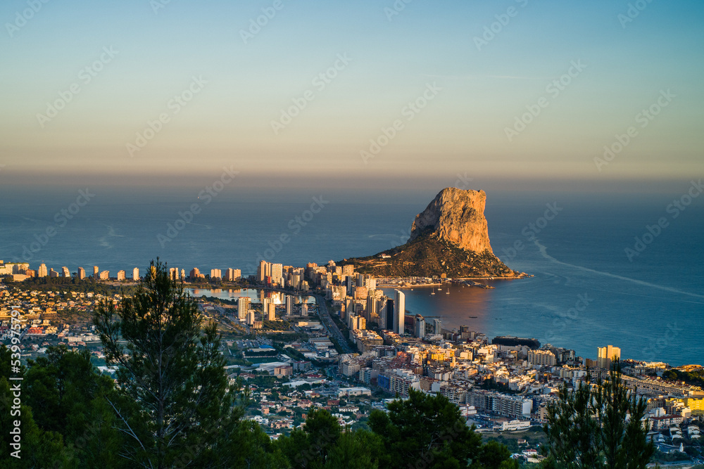 top view of the city of Calpe, the rocks of Ifach and the sea in the evening at sunset