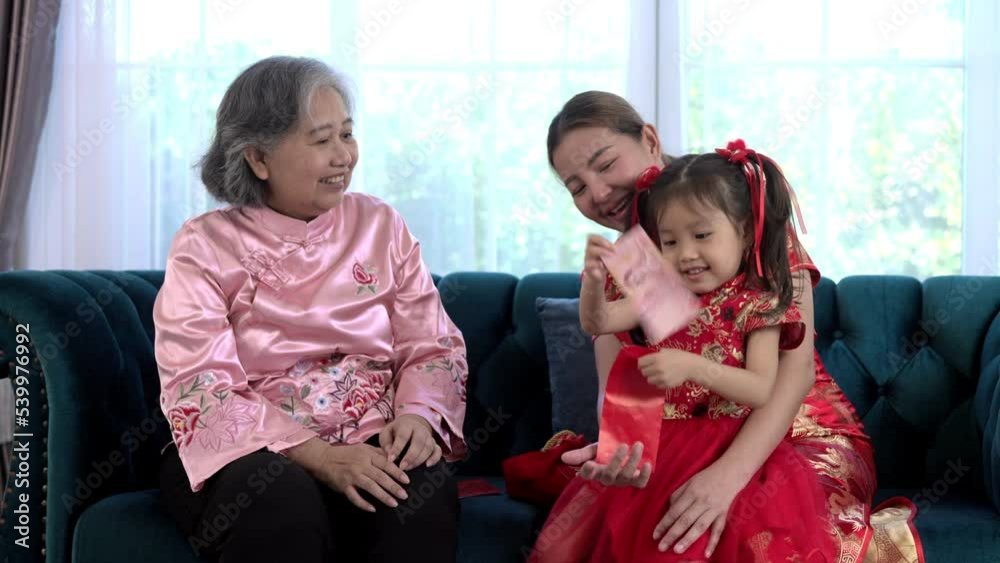 Grandma putting banknotes in a red envelope as a gift during Chinese New Year Grandma putting banknotes in a red envelope as a gift during Chinese New Year