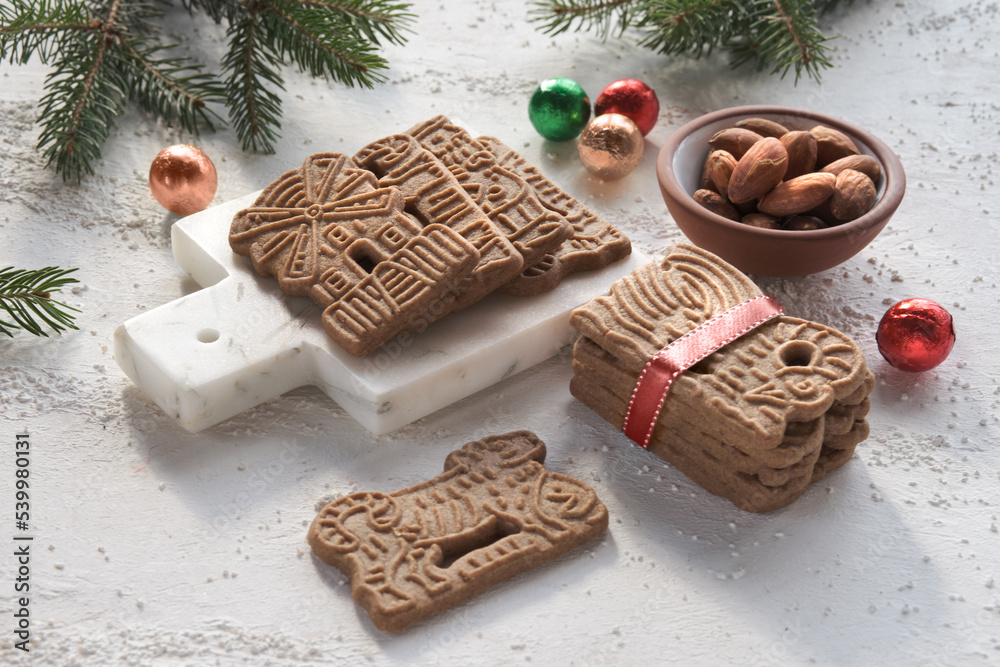 Speculoos or Spekulatius, Christmas biscuits, chocolate balls and almonds on a table with fir twigs. Traditional German sweets, cookies for Christmas or Advent, wintertime snacks. Speculoos or Spekulatius, Christmas biscuits, chocolate balls and almonds on a table with fir twigs. Traditional German sweets, cookies for Christmas or Advent, wintertime snacks.