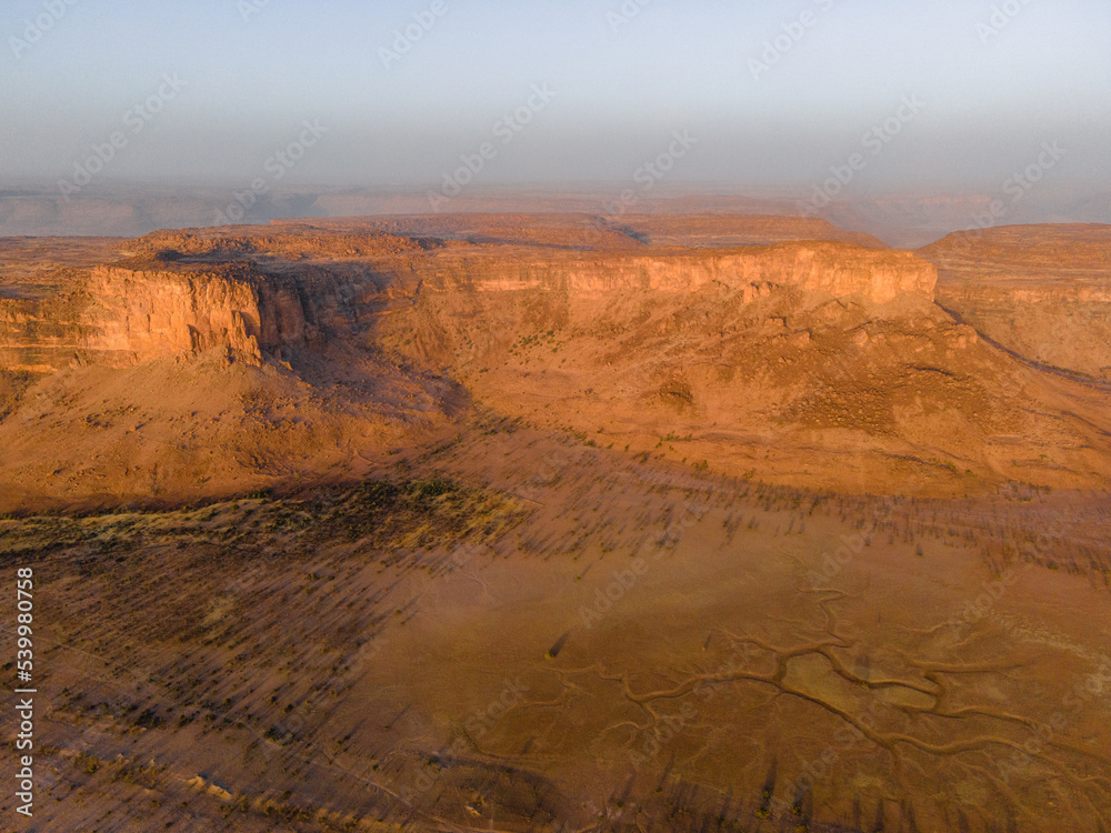 A huge rock cliff and canyon near Kamour, Mauritania, Sahara Desert A huge rock cliff and canyon near Kamour, Mauritania, Sahara Desert