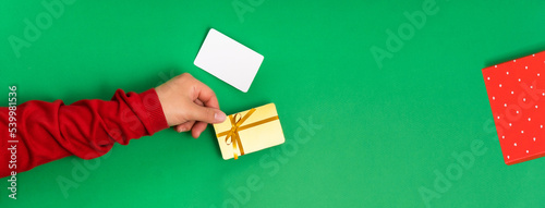 Bonus and gift card template with a bow in female hands on a green background