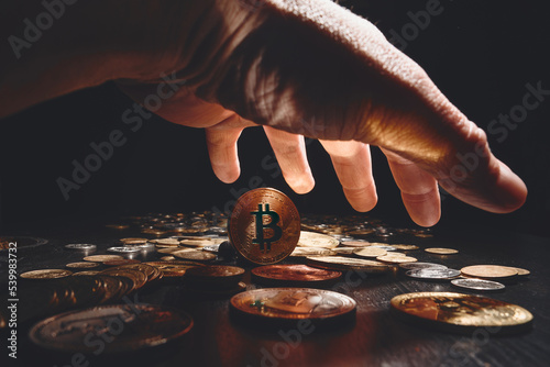 Bitcoin. Cryptocurrency Gold Bitcoin, BTC, Bit Coin. Macro shot of bitcoin coins isolated on black background with human hand. Blockchain technology, bitcoin mining concept.