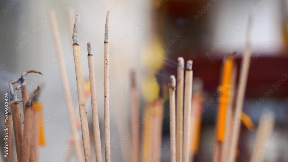 Handheld close up view of Incense burning with background blur Handheld close up view of Incense burning with background blur