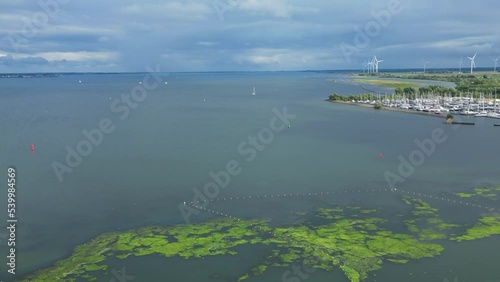 Beautiful Aerial Drone shot over Stellendam, Harbor, Boats are docked, swamp, marsh, and estuary with windmills in the landscape.  photo